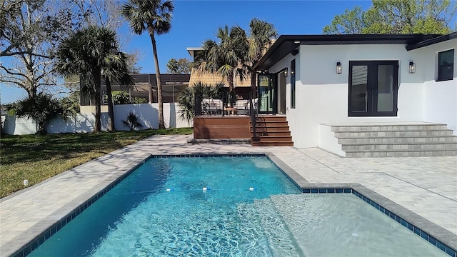 view of swimming pool featuring a patio, french doors, a fenced in pool, and a fenced backyard