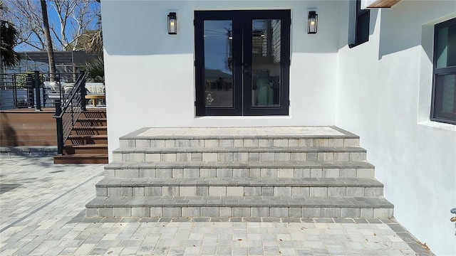 view of exterior entry with stucco siding and french doors