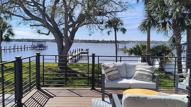 wooden deck with an outdoor living space, a dock, and a water view