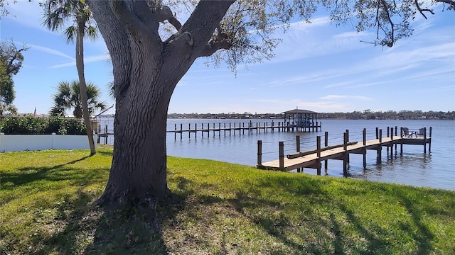 view of dock with a yard and a water view