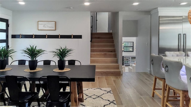 dining room featuring stairway, recessed lighting, and wood finish floors