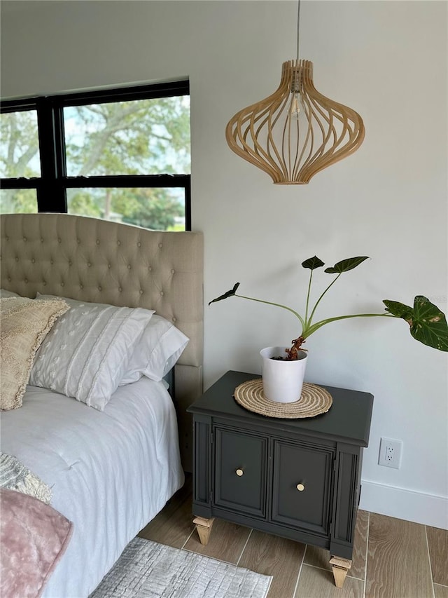 bedroom featuring baseboards and wood finished floors