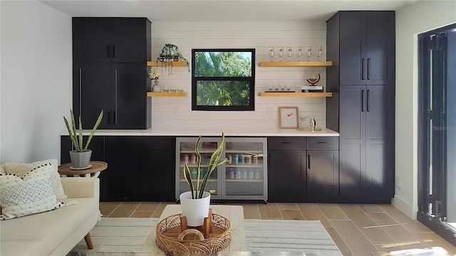 bar featuring wood finish floors, wine cooler, and a dry bar