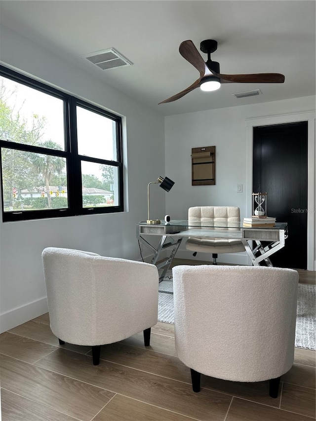 living area with visible vents, baseboards, and wood finished floors