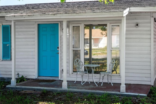 property entrance featuring roof with shingles