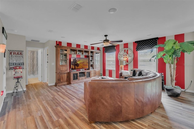 living room with baseboards, ceiling fan, visible vents, and light wood-style floors