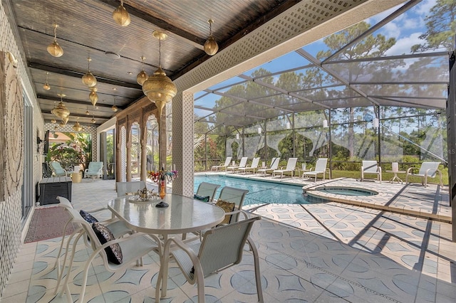 view of patio featuring glass enclosure and a pool with connected hot tub