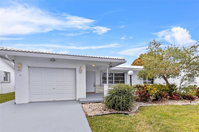 view of front of house featuring a garage, driveway, a tile roof, and stucco siding