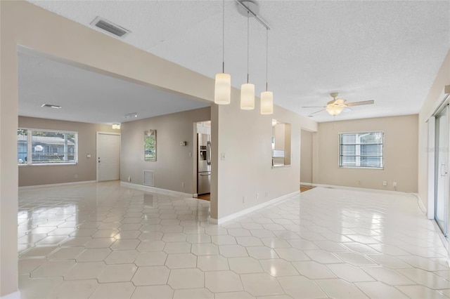 spare room with a healthy amount of sunlight, visible vents, and light tile patterned flooring