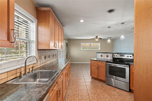 kitchen featuring light tile patterned floors, a sink, visible vents, tasteful backsplash, and stainless steel range with electric stovetop