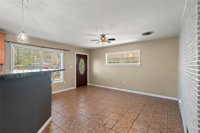 entryway with baseboards, visible vents, a ceiling fan, and light tile patterned flooring