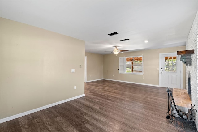 unfurnished living room with dark wood-type flooring, a fireplace, and baseboards