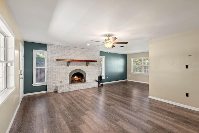 unfurnished living room featuring a fireplace, wood finished floors, visible vents, a ceiling fan, and baseboards