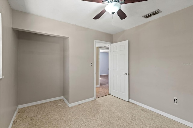 unfurnished bedroom with baseboards, a ceiling fan, visible vents, and light colored carpet