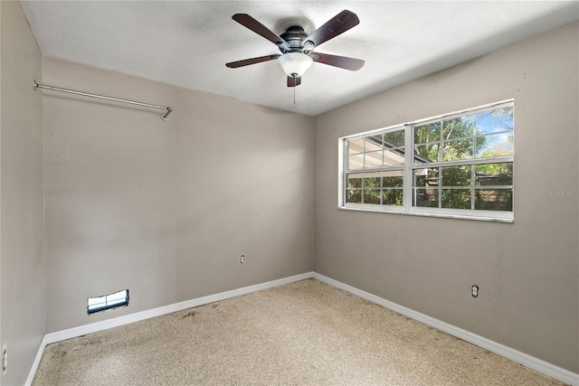 spare room featuring a textured ceiling, baseboards, and a ceiling fan