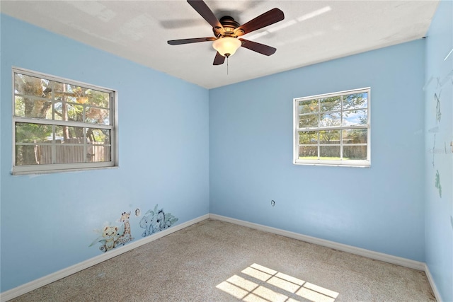 spare room featuring a ceiling fan and baseboards