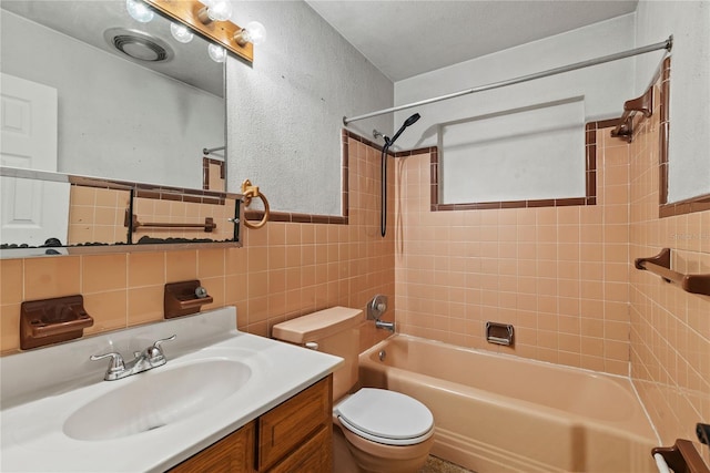 full bath with a textured wall, toilet, shower / tub combination, vanity, and tile walls