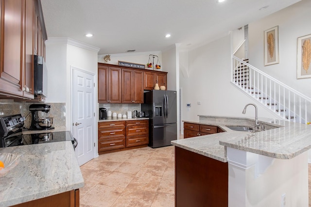 kitchen with tasteful backsplash, electric stove, light stone counters, black refrigerator with ice dispenser, and a sink