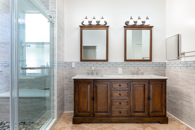 full bath featuring a shower stall, tile walls, and a sink