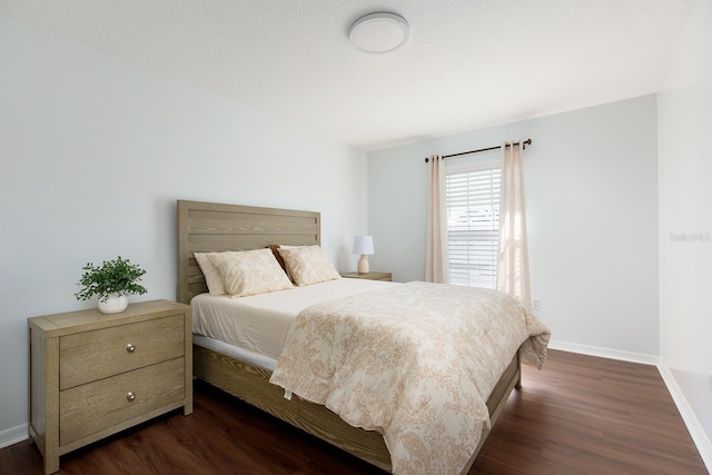 bedroom featuring dark wood finished floors and baseboards