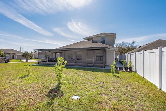 rear view of house featuring a yard and fence