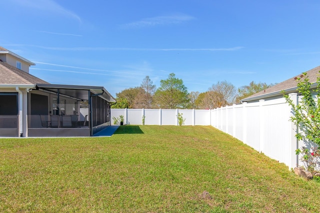 view of yard with a fenced backyard and a sunroom