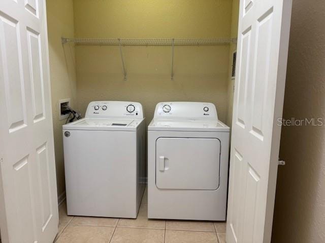 washroom with light tile patterned flooring and washing machine and dryer