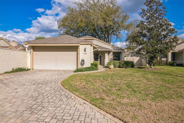 ranch-style home with an attached garage, fence, decorative driveway, stucco siding, and a front yard