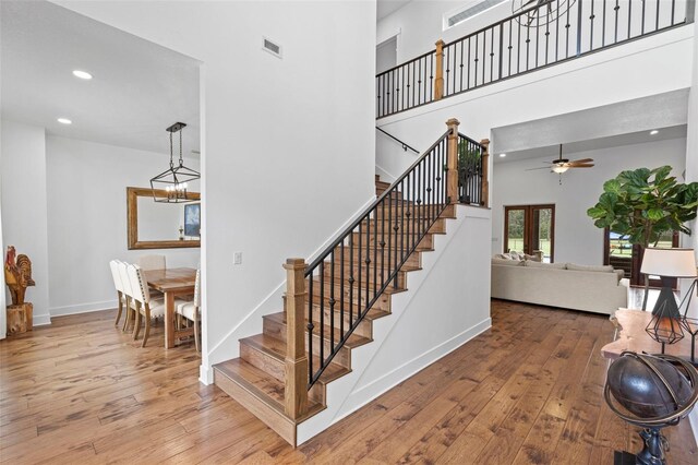 5500 State Road 33, Clermont, FL 34714 - stairway with hardwood / wood-style flooring, a towering ceiling, visible vents, and baseboards