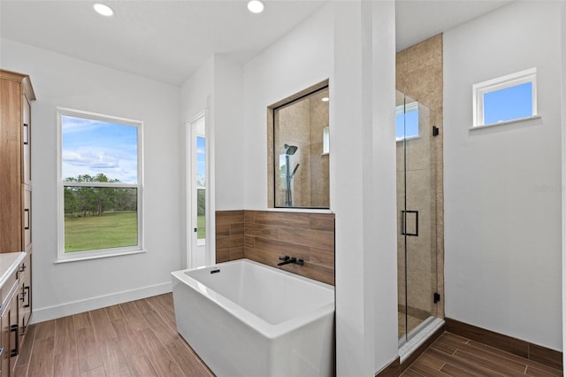 5500 State Road 33, Clermont, FL 34714 - full bath featuring a freestanding tub, wood finished floors, vanity, baseboards, and a stall shower