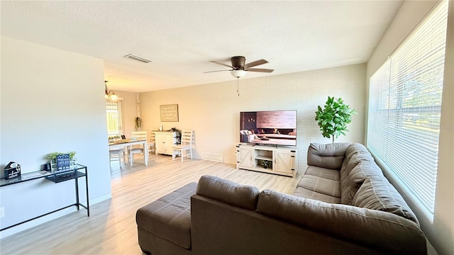 1420 Continental Dr, Daytona Beach, FL 32117 - living room featuring light wood-type flooring, a chandelier, a ceiling fan, and a textured ceiling