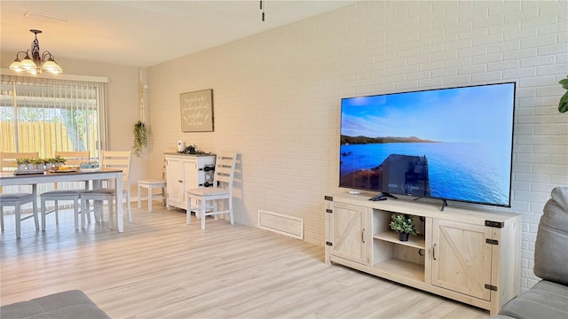 1420 Continental Dr, Daytona Beach, FL 32117 - living area featuring light wood-style flooring, a chandelier, and brick wall