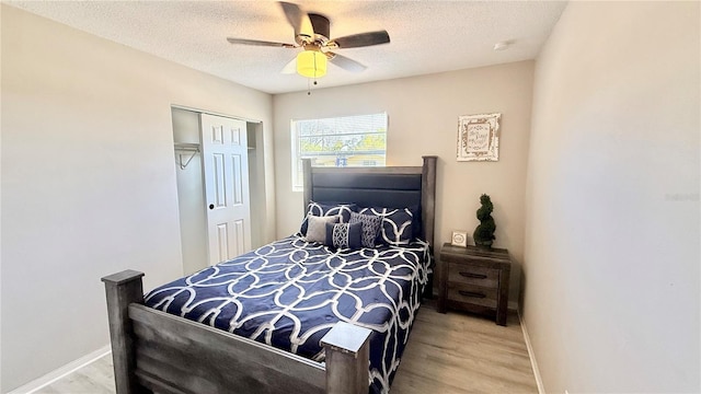 1420 Continental Dr, Daytona Beach, FL 32117 - bedroom featuring wood finished floors, baseboards, a closet, a textured ceiling, and ceiling fan