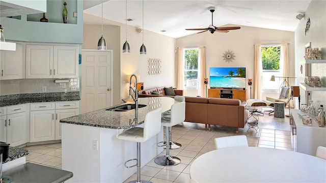 kitchen with light tile patterned floors, a healthy amount of sunlight, ceiling fan, a sink, and open floor plan