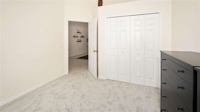 unfurnished bedroom with carpet flooring, baseboards, and a closet