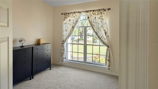 bedroom with multiple windows, baseboards, and light carpet