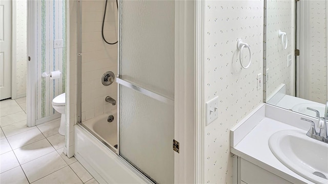 full bathroom featuring tile patterned floors, toilet, wallpapered walls, and shower / bath combination with glass door