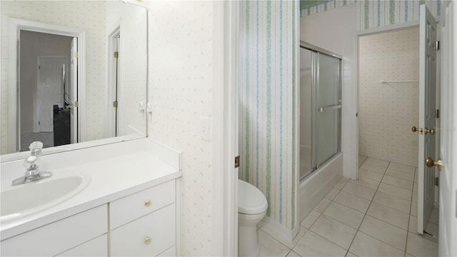 bathroom with wallpapered walls, toilet, vanity, and tile patterned flooring