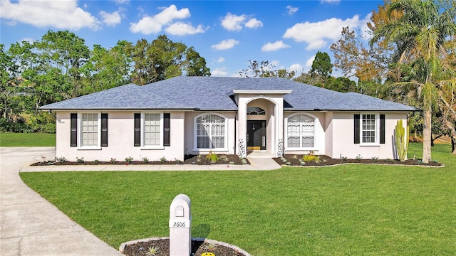 single story home with a front lawn, driveway, roof with shingles, and stucco siding