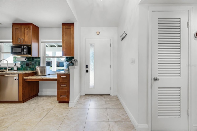 kitchen featuring tasteful backsplash, brown cabinetry, light tile patterned flooring, black microwave, and dishwasher