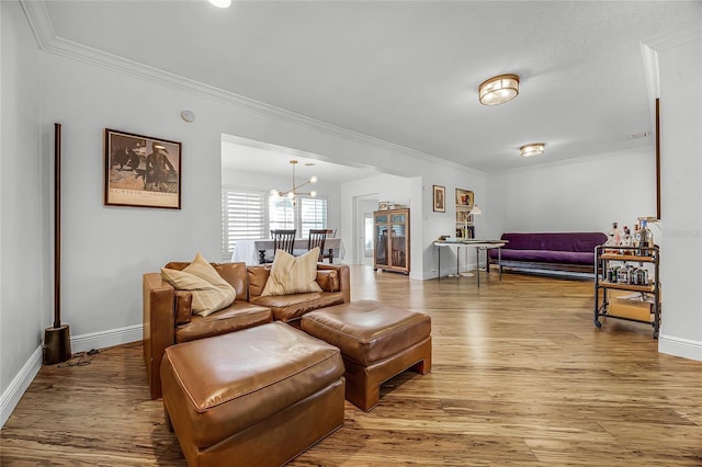 living area featuring ornamental molding, light wood-style flooring, and baseboards