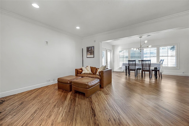 living room with ornamental molding, plenty of natural light, baseboards, and wood finished floors