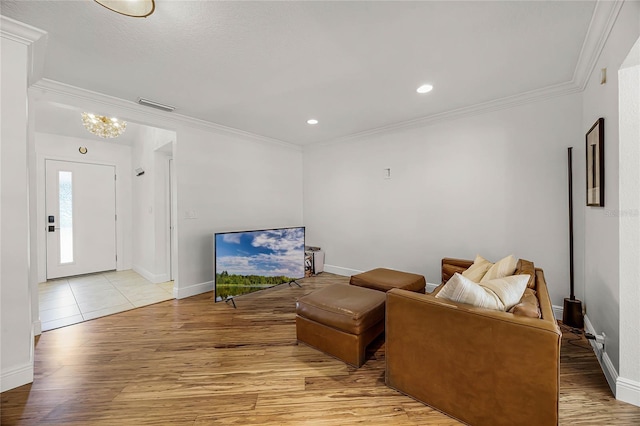 living area featuring ornamental molding, light wood-type flooring, and visible vents