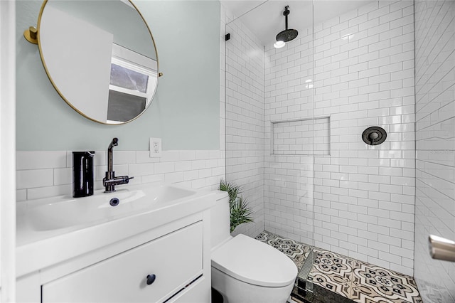 bathroom featuring tile walls, a tile shower, vanity, and toilet