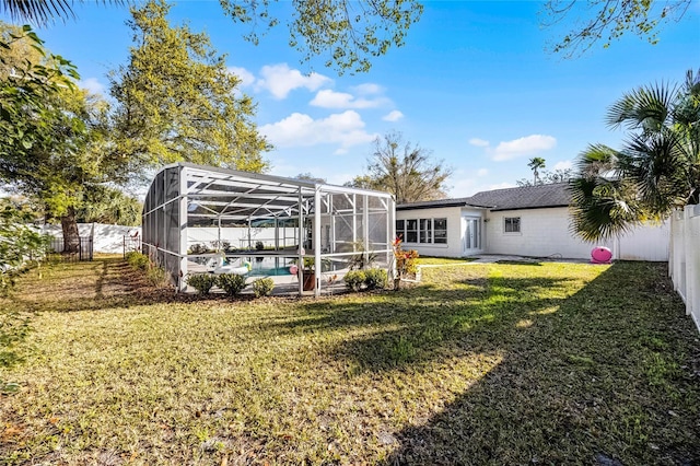 exterior space featuring glass enclosure, a fenced backyard, and a fenced in pool