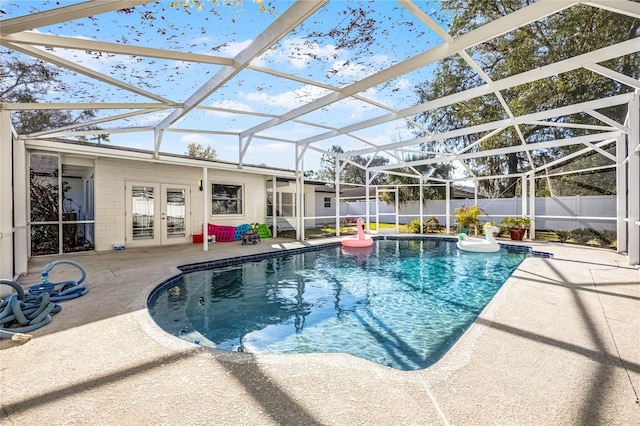 view of swimming pool featuring a fenced backyard, a lanai, french doors, a fenced in pool, and a patio area