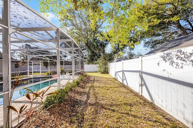 view of yard featuring a lanai, a fenced backyard, and a fenced in pool