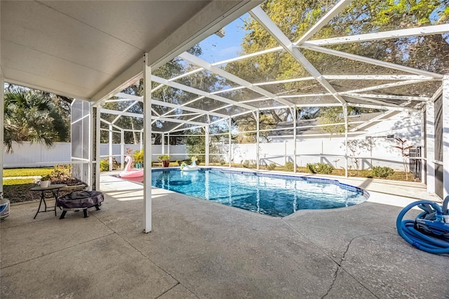 view of pool with glass enclosure, a patio area, a fenced backyard, and a fenced in pool