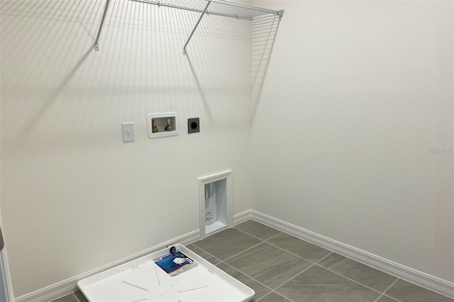 clothes washing area with baseboards, laundry area, dark tile patterned floors, and hookup for an electric dryer