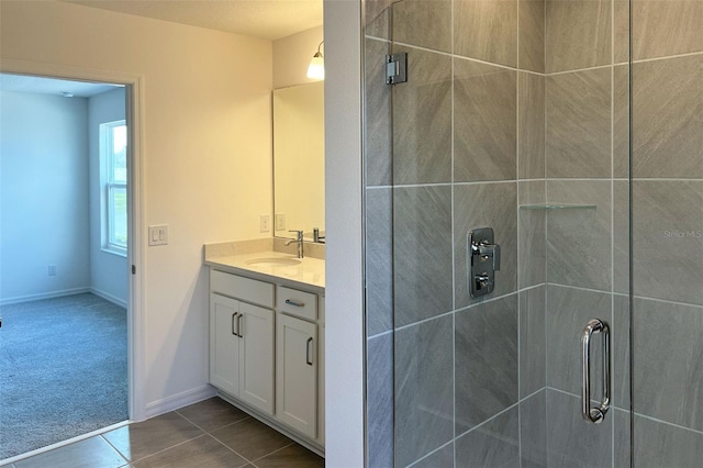 full bath featuring a stall shower, vanity, and baseboards